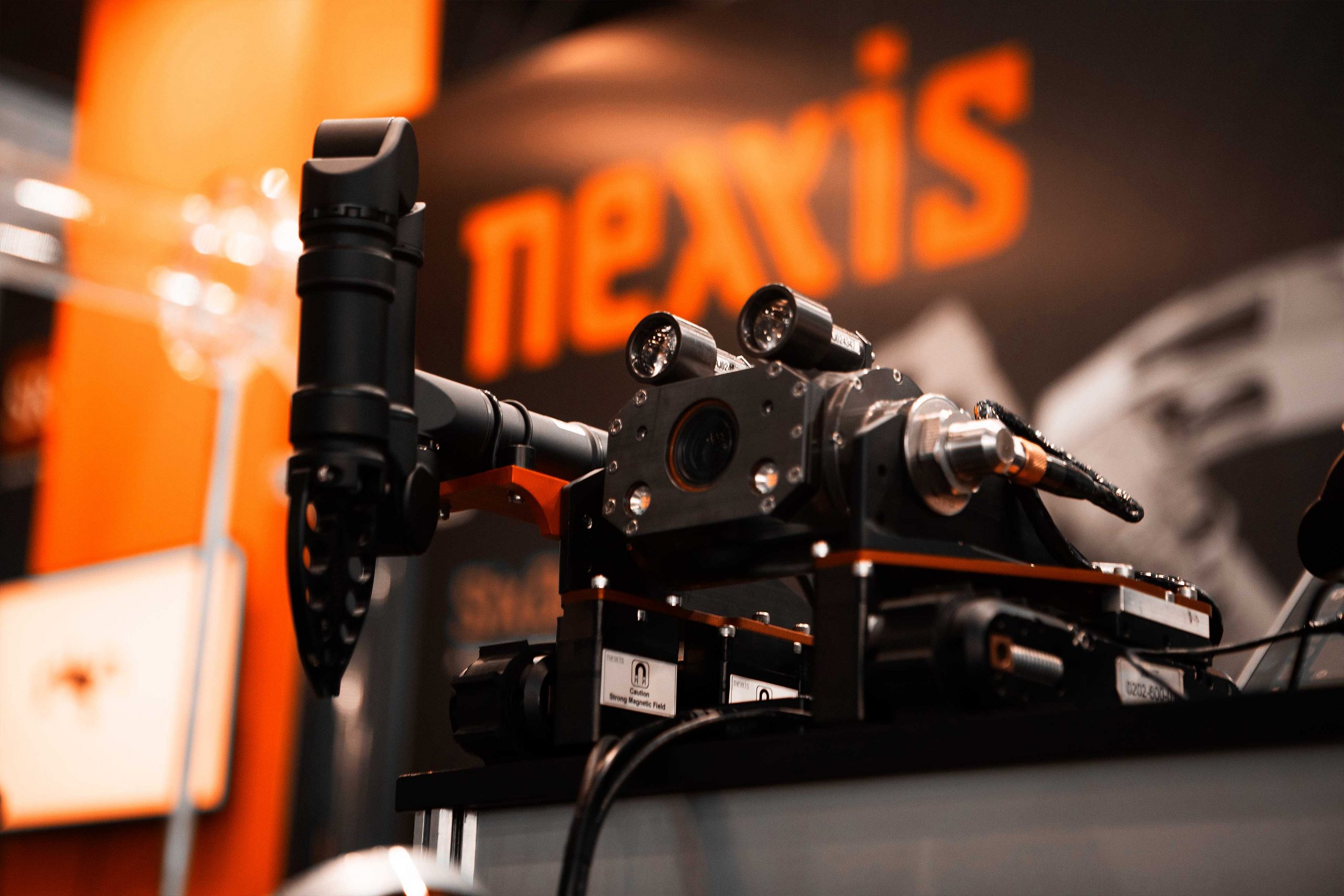 Close up of black robotic with black and orange Nexxis sign behind